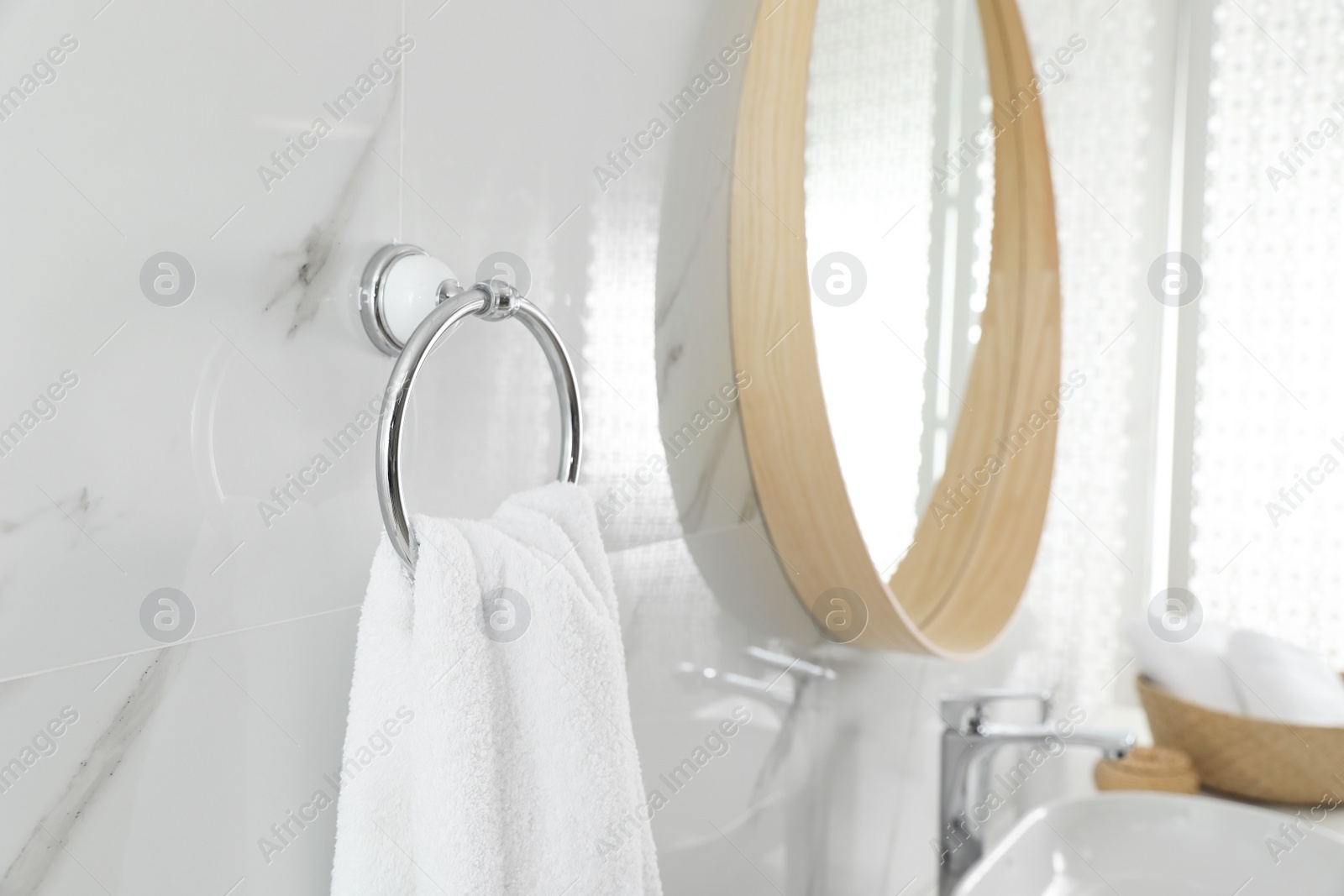 Photo of Holder with clean towel on light wall in bathroom