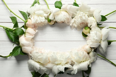 Flat lay composition with beautiful blooming peonies on wooden background