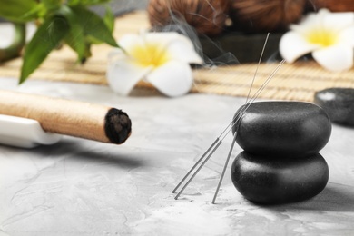 Photo of Needles for acupuncture and stones on table