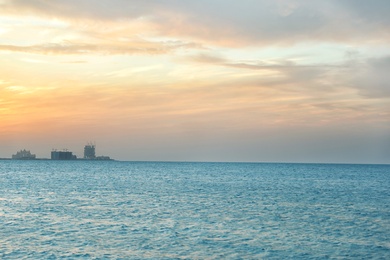 Beautiful view of sea, distant city on shore and amazing sunset sky