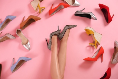 Woman and different high heel shoes on pink background, top view