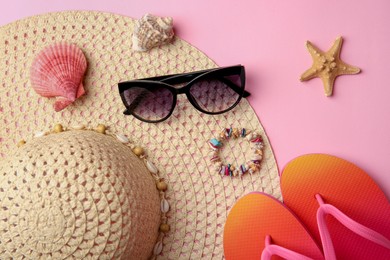 Flat lay composition with beach accessories on pink background