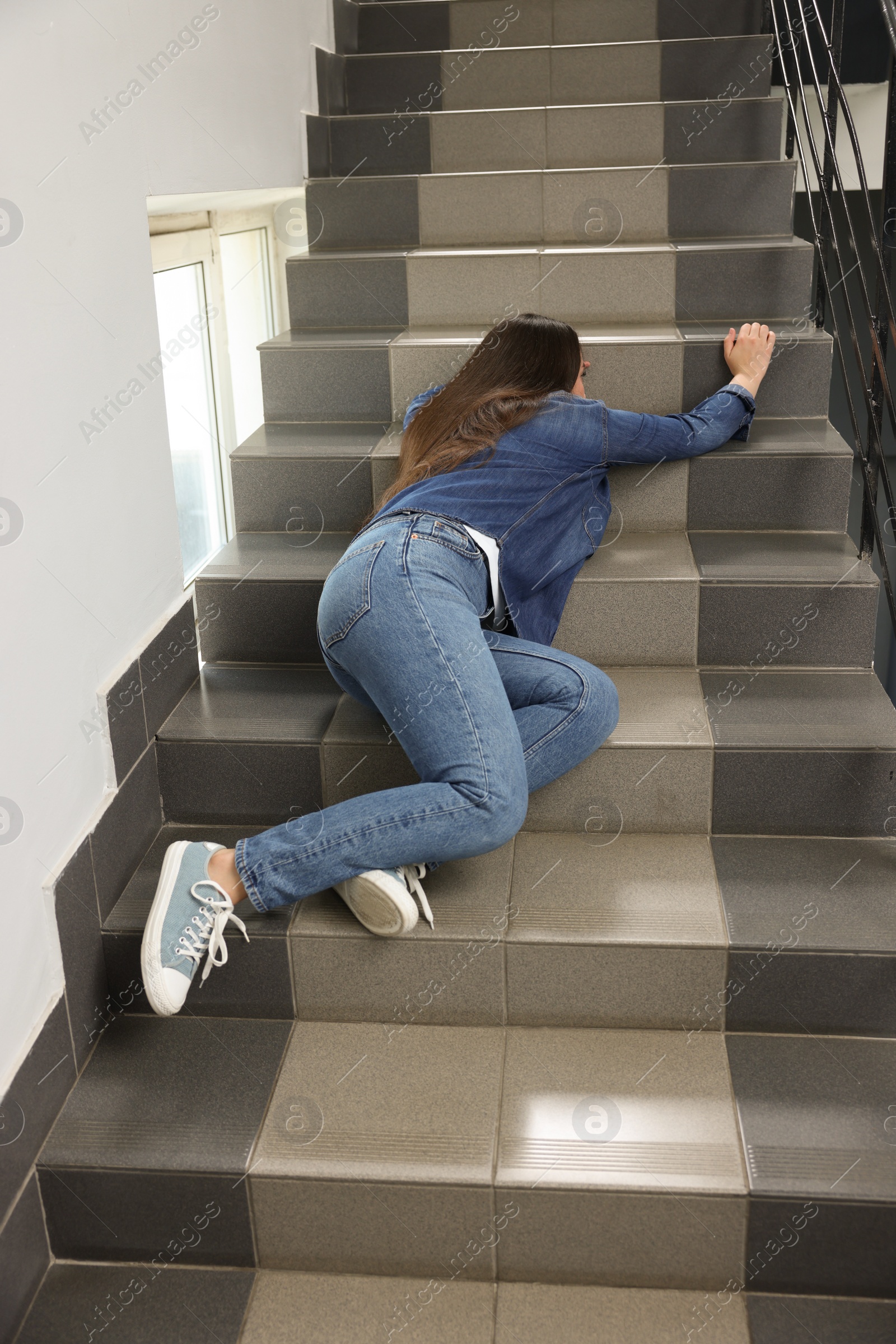 Photo of Unconscious woman lying on stairs after falling down indoors