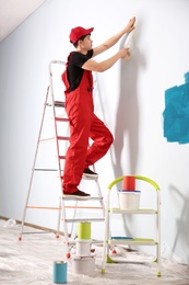 Male decorator working with tape indoors