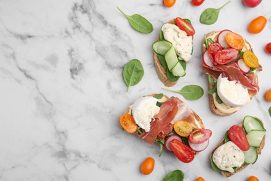 Photo of Delicious burrata sandwiches served on white marble table, flat lay. Space for text