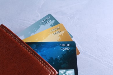 Photo of Credit cards in leather wallet on grey textured table