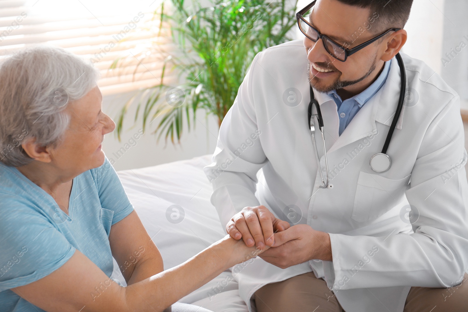 Photo of Doctor visiting senior patient in modern hospital