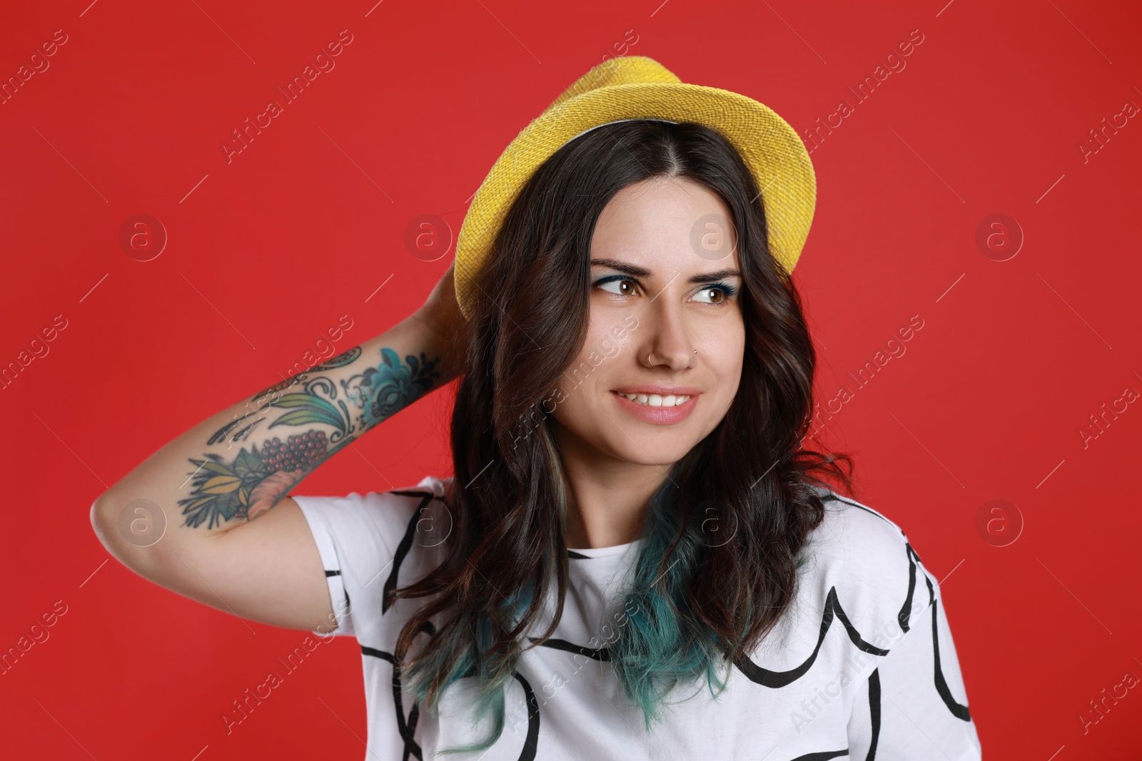 Photo of Beautiful young woman with nose piercing on red background