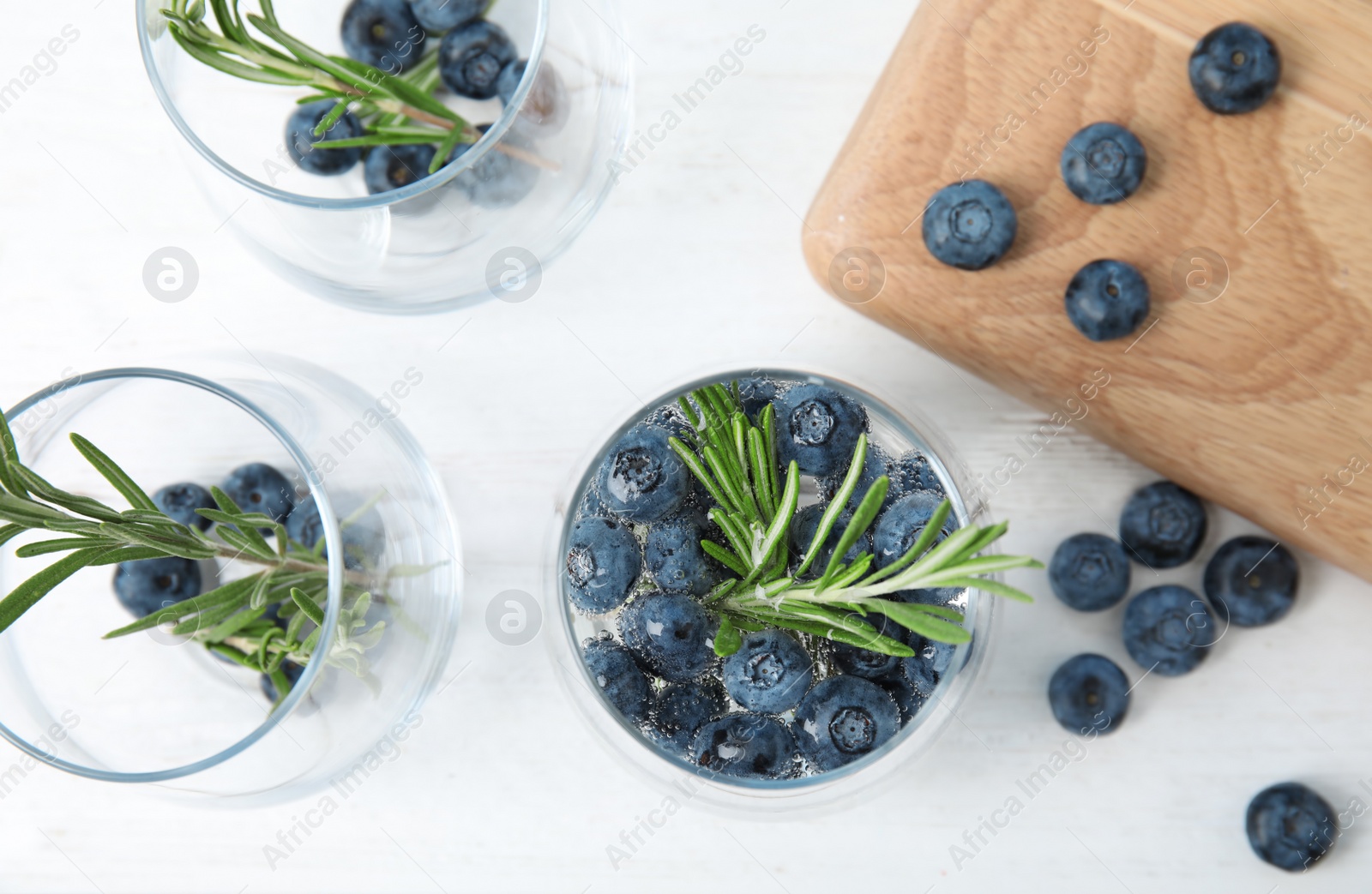 Photo of Flat lay composition with blueberry and rosemary cocktail on light table
