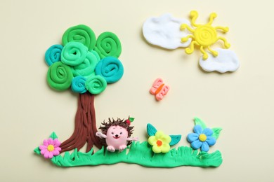 Colorful tree, hedgehog, sun and flowers made with play dough on beige background, flat lay