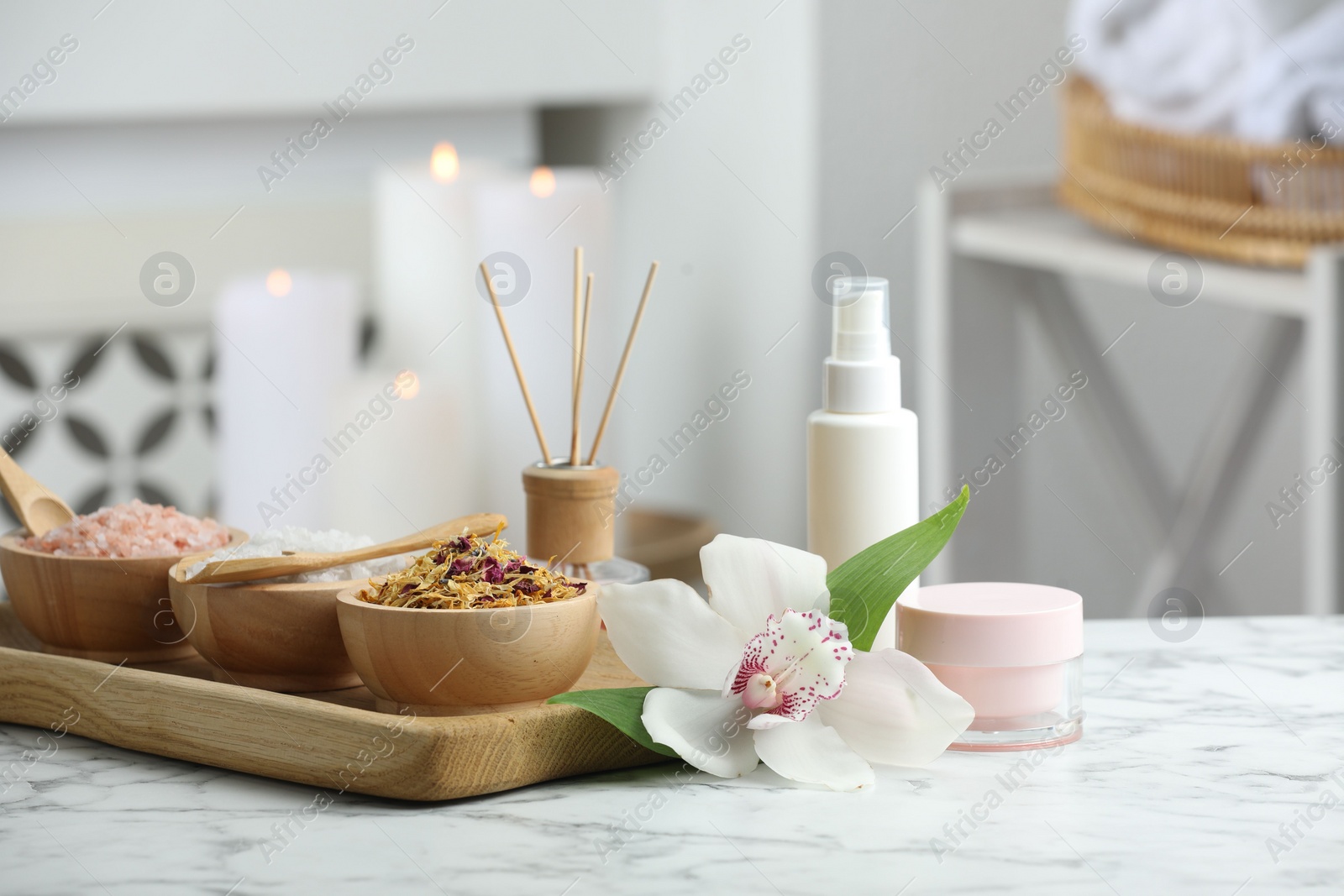 Photo of Beautiful composition with different spa products and orchid flower on white marble table indoors