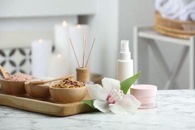 Photo of Beautiful composition with different spa products and orchid flower on white marble table indoors