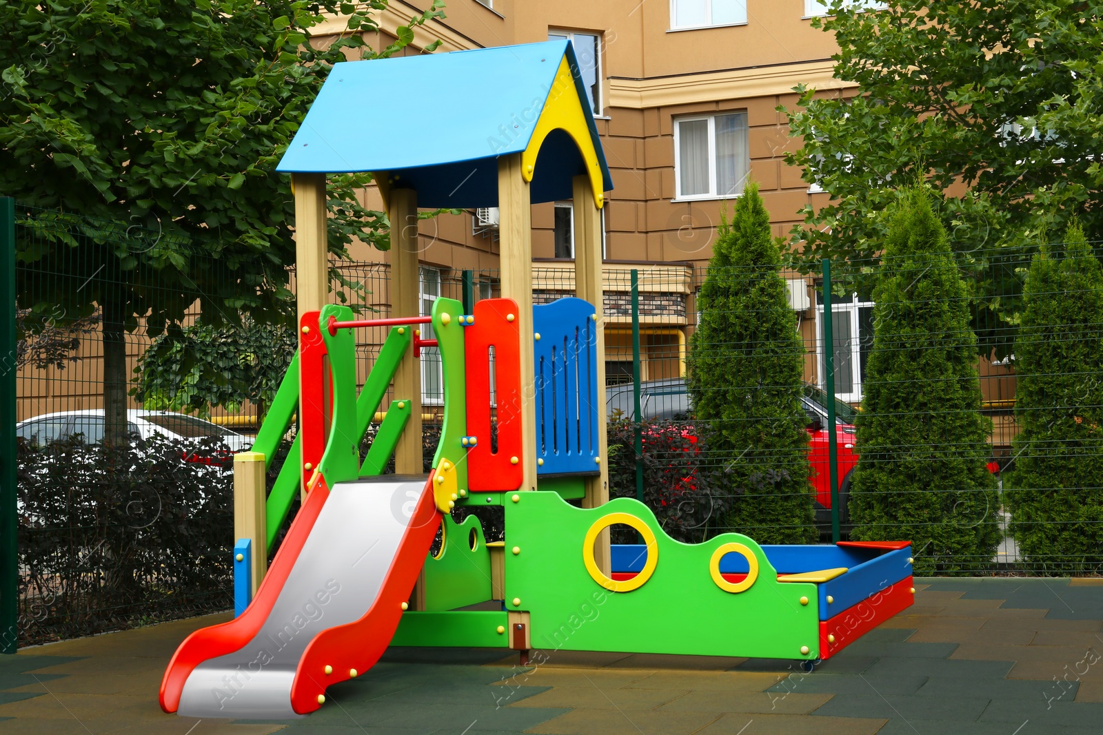 Photo of Empty outdoor children's playground with slide in residential area