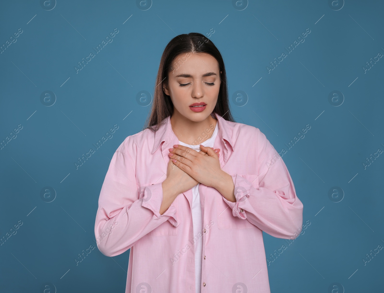 Photo of Young woman suffering from cold on blue background