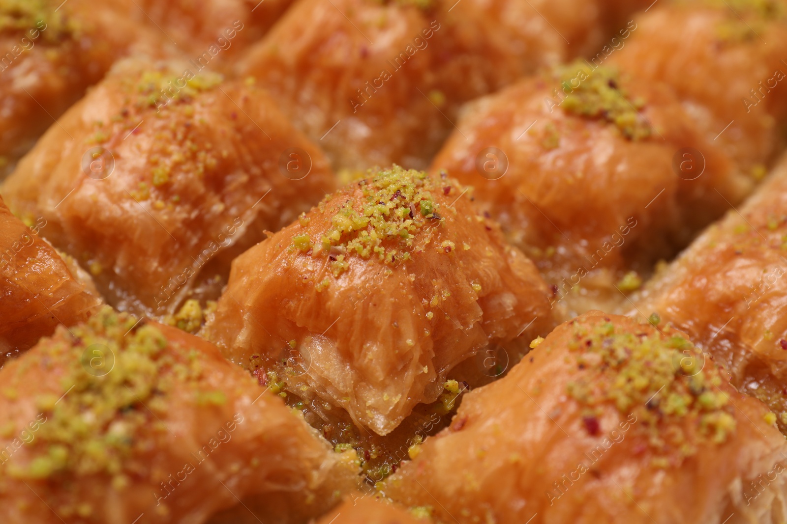 Photo of Delicious sweet baklava with pistachios as background, closeup