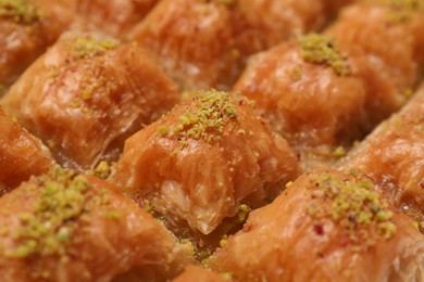 Delicious sweet baklava with pistachios as background, closeup