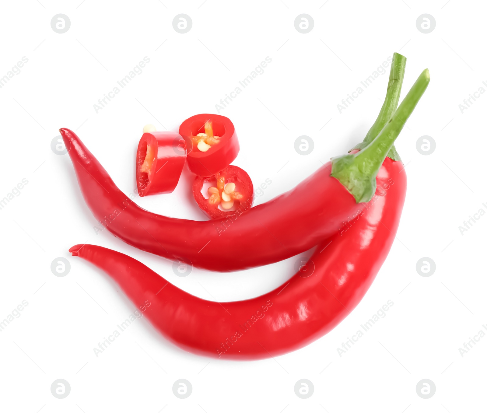 Photo of Cut and whole red hot chili peppers on white background