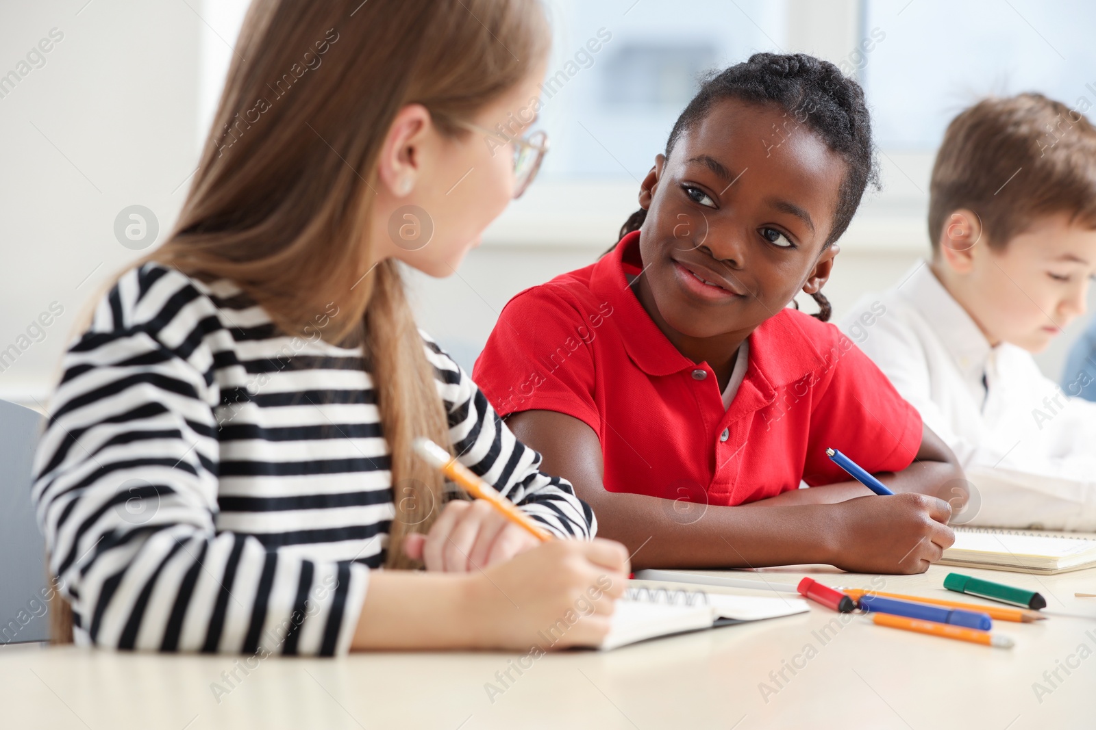 Photo of Cute children studying in classroom at school