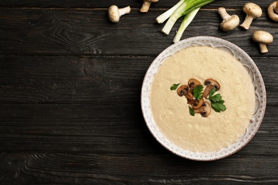 Photo of Flat lay composition with bowl of fresh homemade mushroom soup and space for text on wooden background