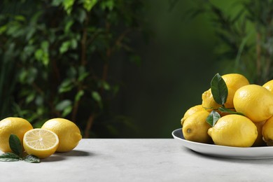 Fresh lemons and green leaves on table outdoors