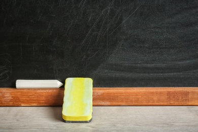 Photo of Chalk and duster on table in classroom