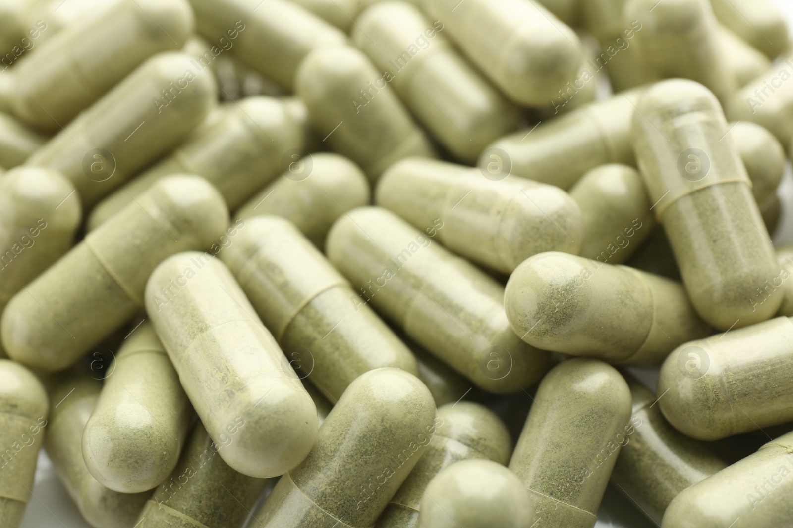 Photo of Light green vitamin capsules as background, closeup