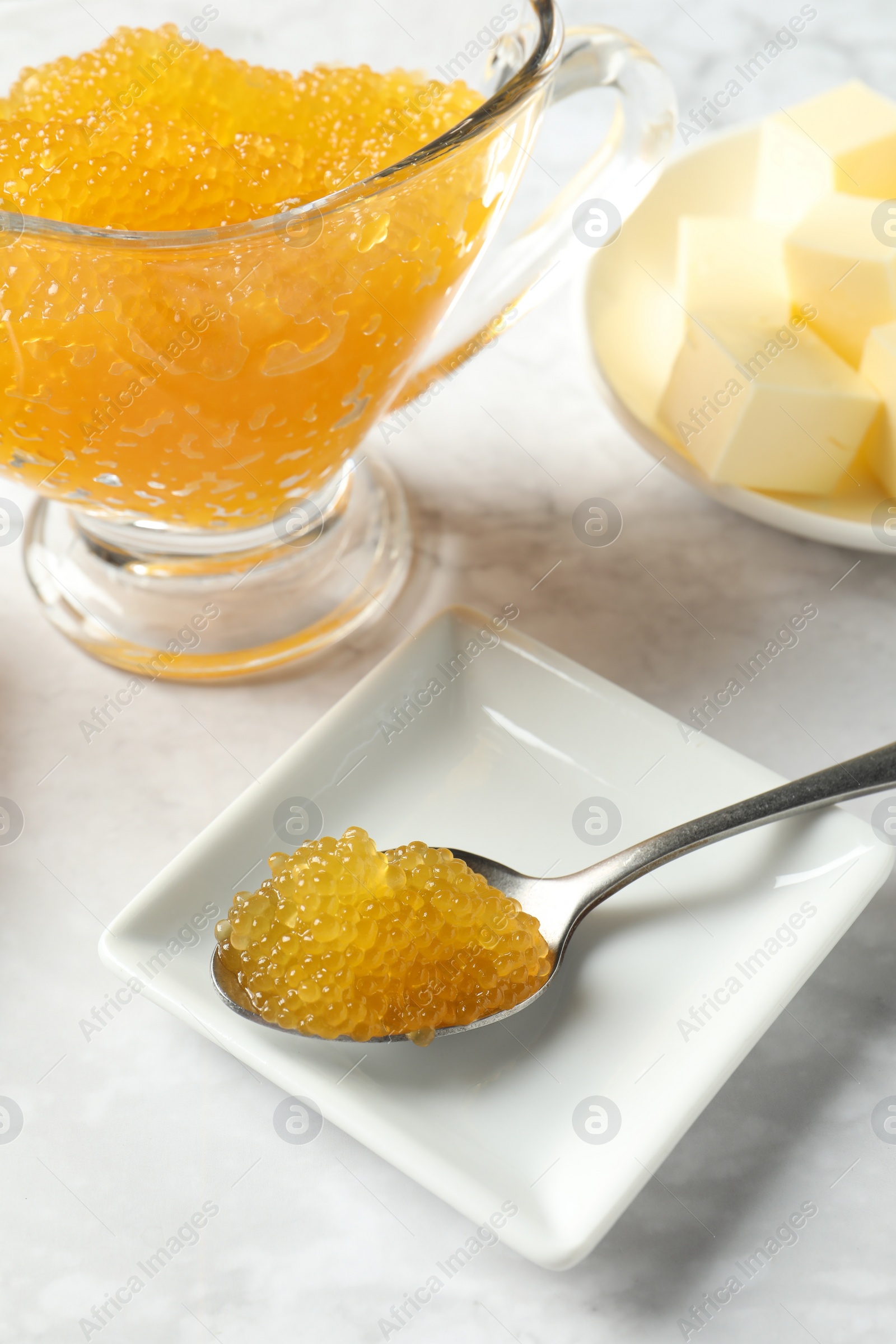 Photo of Fresh pike caviar and butter on white marble table