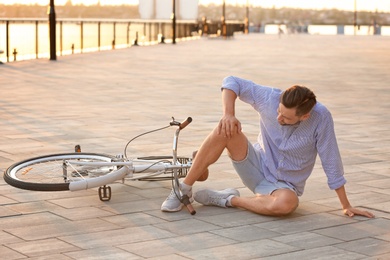 Man fallen off his bicycle on street