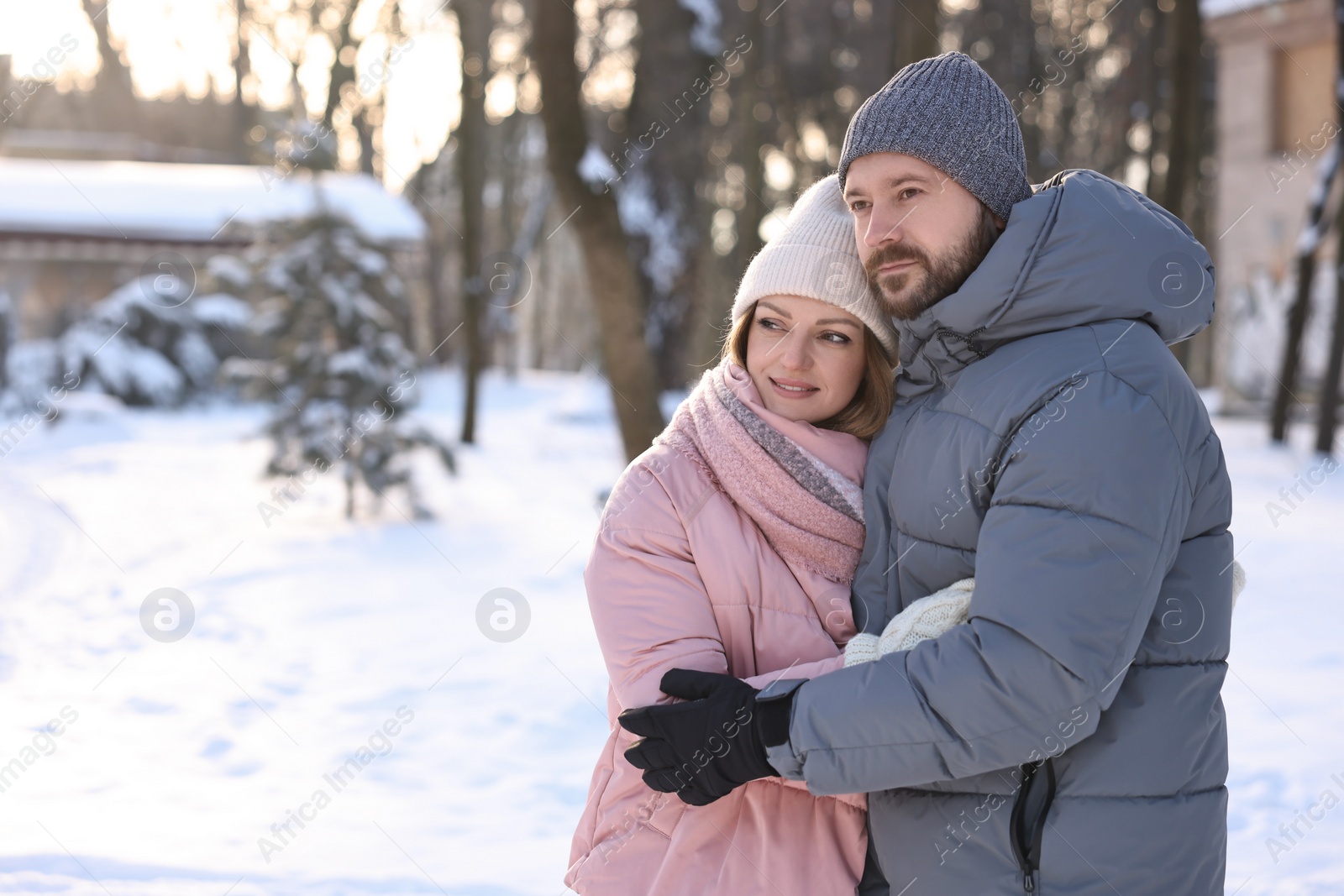 Photo of Family portrait of beautiful couple in snowy park. Space for text