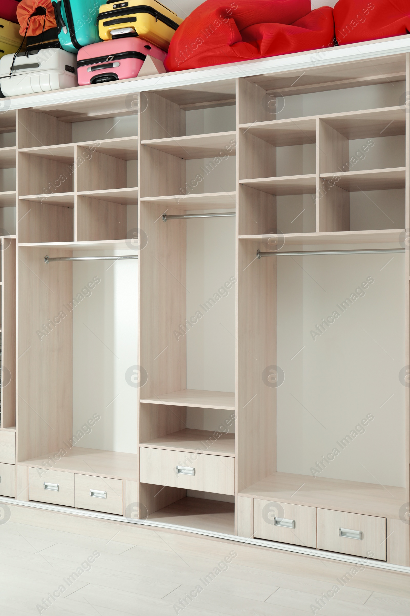 Photo of Empty wardrobe with bags and suitcases on top in dressing room