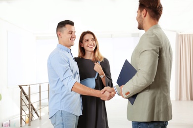 Real estate agent with young couple in new apartment