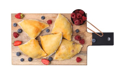 Wooden board with delicious samosas and berries isolated on white, top view