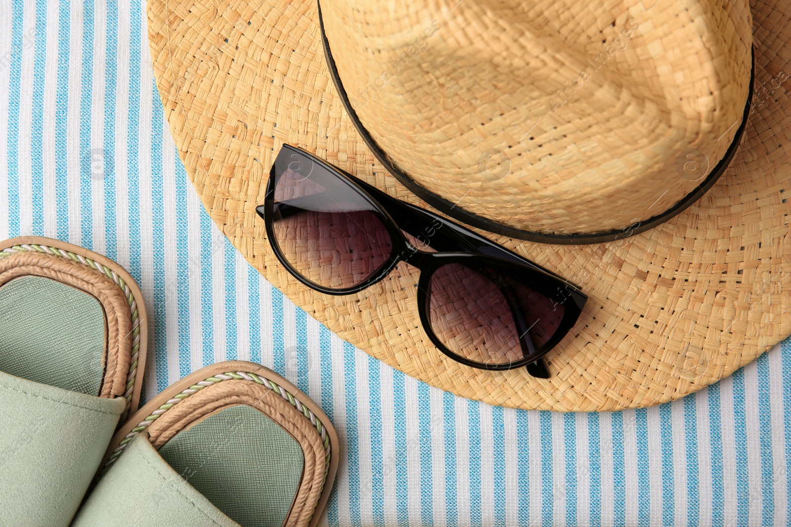 Photo of Flat lay composition with beach accessories on striped blanket