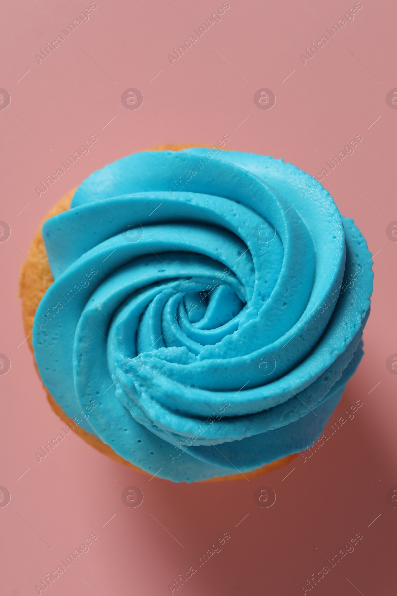 Photo of Delicious cupcake with bright cream on pink background, top view