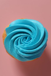 Photo of Delicious cupcake with bright cream on pink background, top view