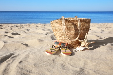 Set with stylish beach accessories on sand near sea