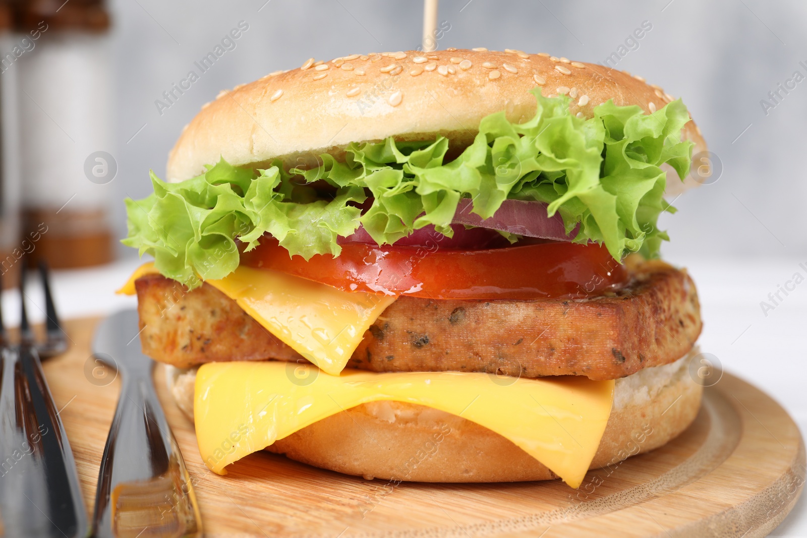 Photo of Delicious burger with tofu and fresh vegetables served on table, closeup