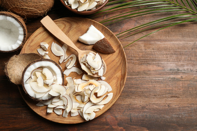 Photo of Flat lay composition with tasty coconut chips on wooden table