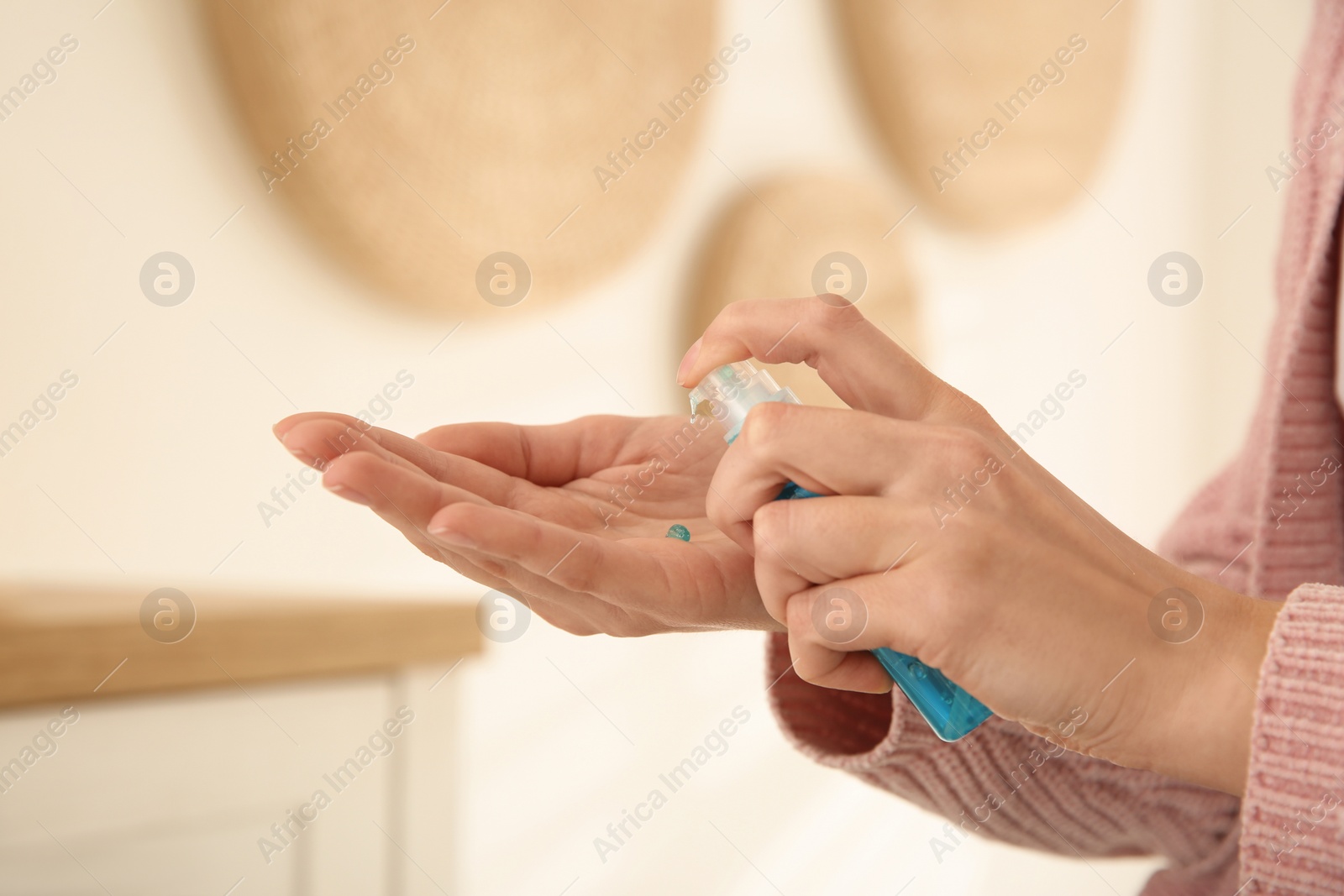 Photo of Woman applying antiseptic gel at home, closeup