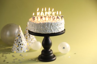 Photo of Tasty birthday cake with burning candles on green background, closeup