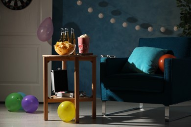 Beer, snacks and poker set in room decorated for party