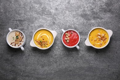 Photo of Different tasty cream soups on grey table, flat lay