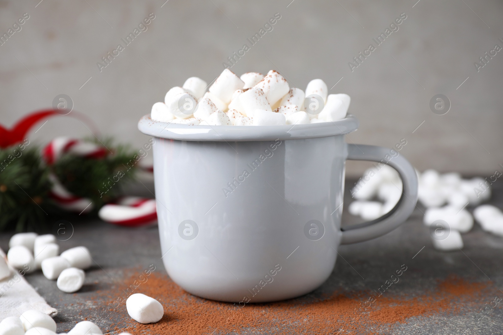 Photo of Cup of tasty hot drink with marshmallows on grey table
