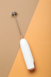 Photo of White milk frother wand on color background, top view