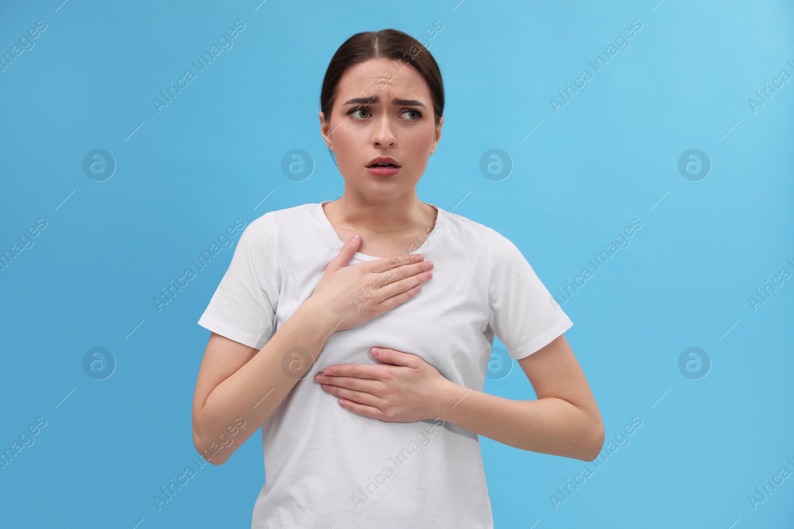 Photo of Woman suffering from cold on light blue background