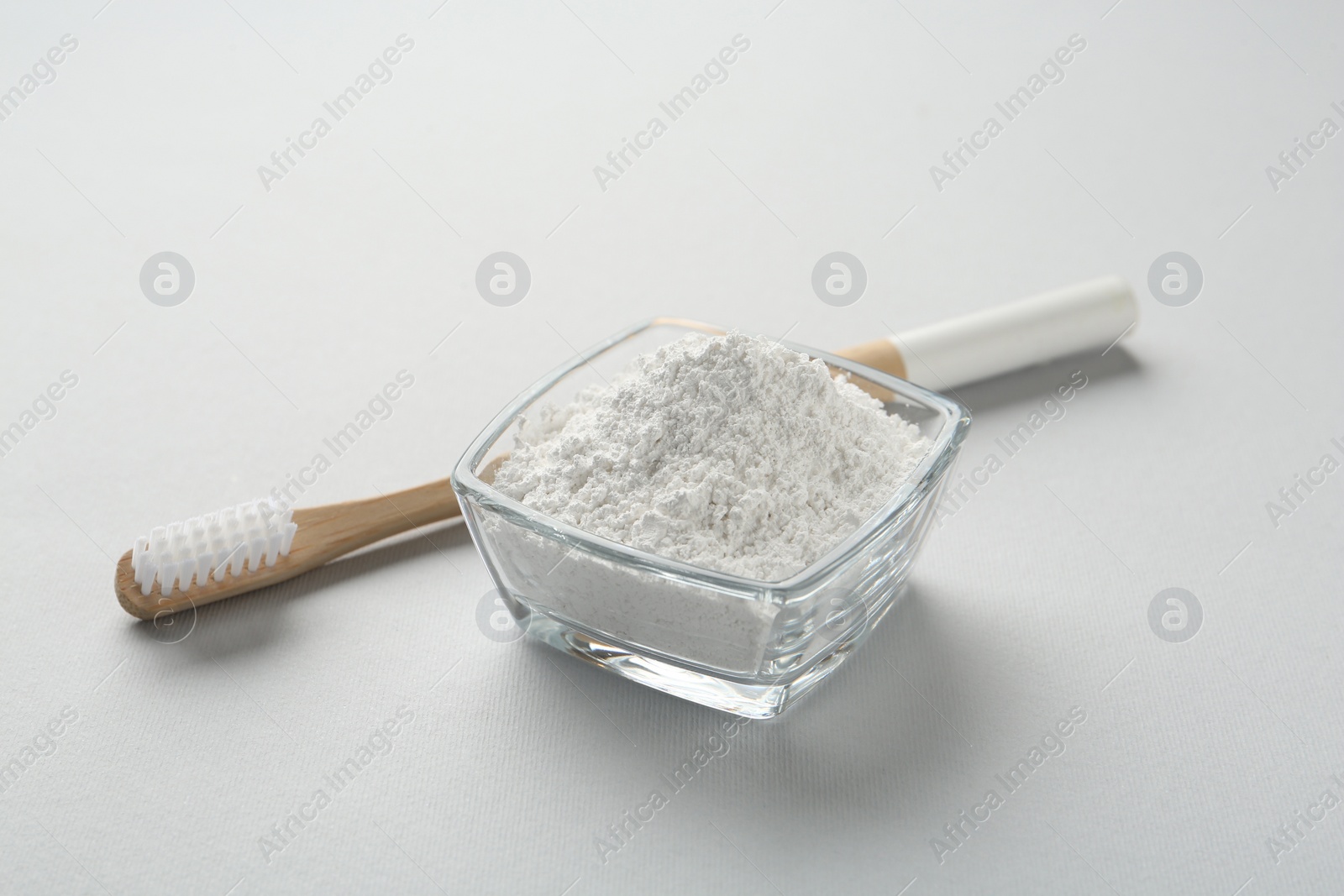 Photo of Tooth powder and brush on white background