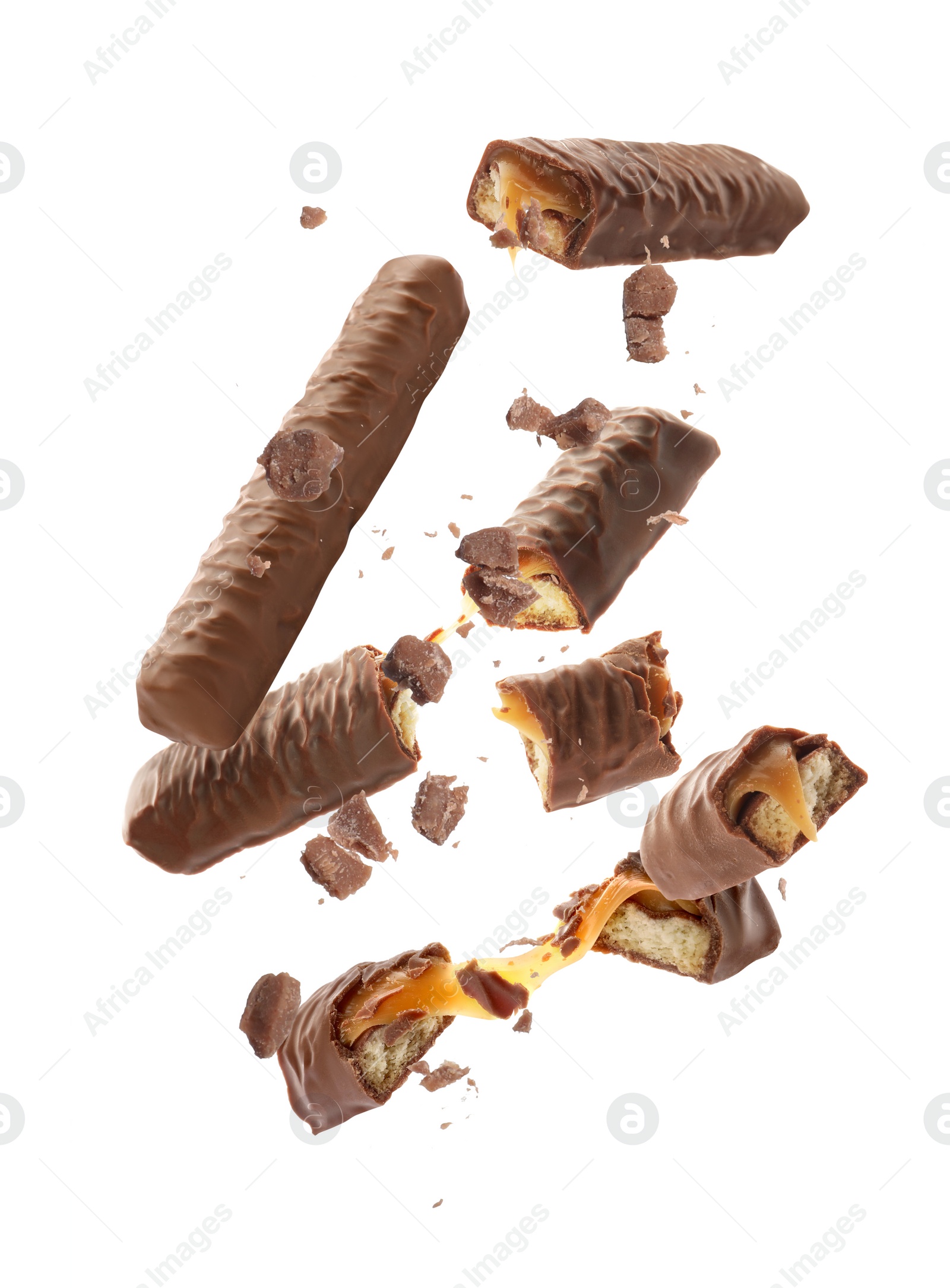 Image of Whole and broken chocolate bars with caramel falling on white background