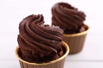 Photo of Delicious chocolate cupcakes on white table, closeup