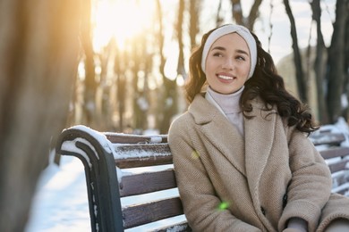 Portrait of smiling woman in sunny snowy park. Space for text