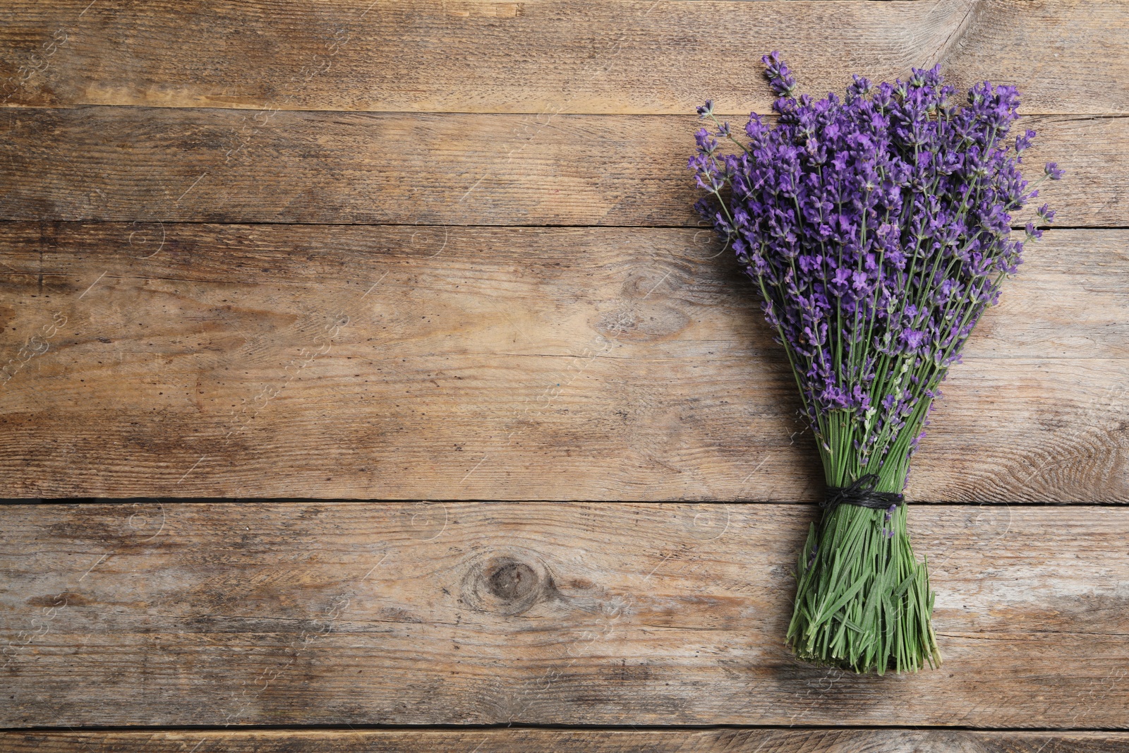 Photo of Beautiful lavender bouquet on wooden background, top view. Space for text